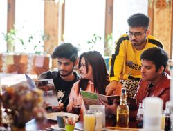 group-asian-friends-sitting-cafe-happy-indian-people-having-fun-together-sitting-couch-choose-meals-from-menu